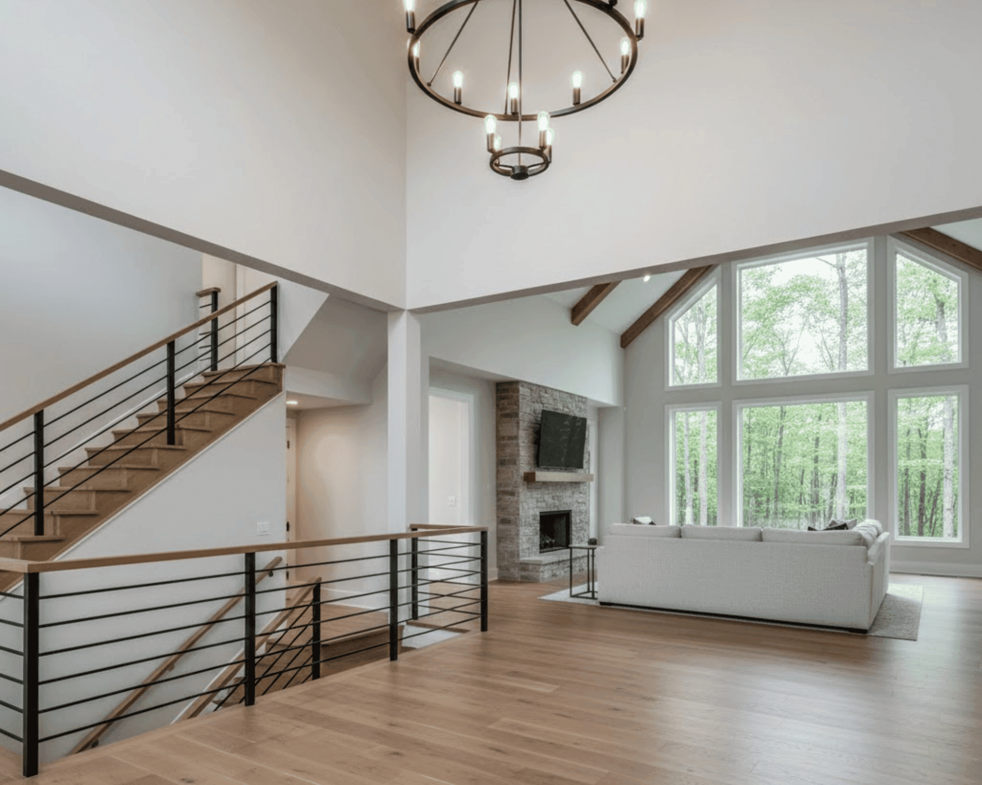 Grand foyer with double-height ceiling, chandelier, and stone fireplace